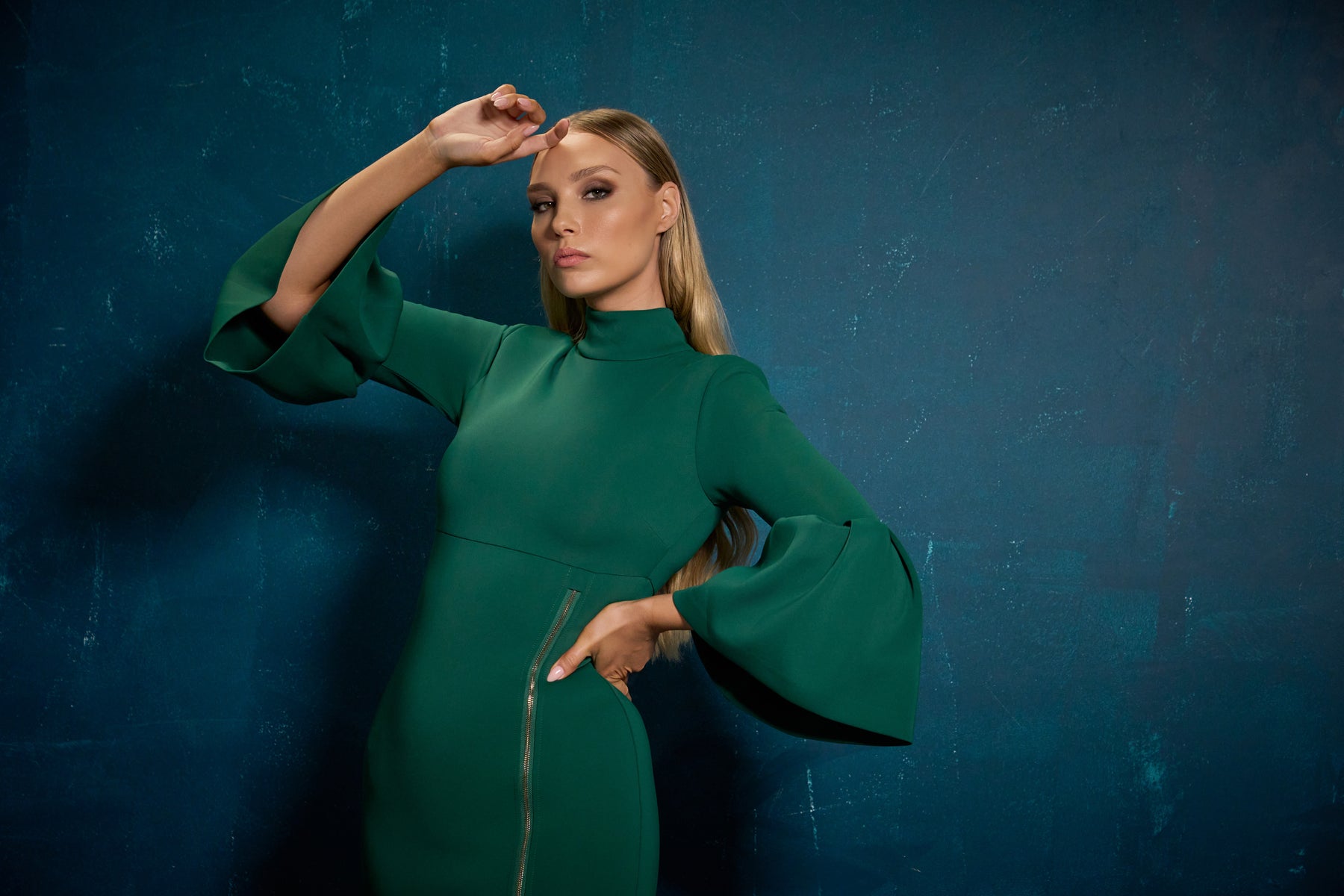 Woman in a green dress posing against a blue background 

The Provocateur Dress (Green) by Lady Milan (Fall - Winter 2026 Collection by Lady Milan)
